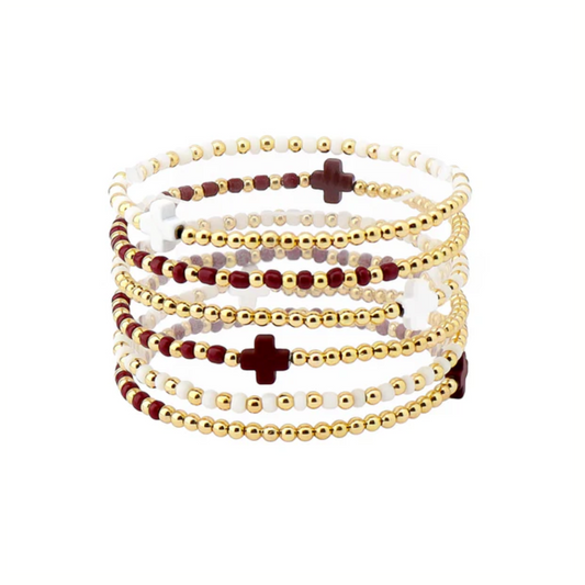 The Gameday Maroon and White Beaded Stretch Bracelets by What's Hot feature layered gold, burgundy, and white beads with cross accents—perfect stacked maroon and white jewelry for gameday.