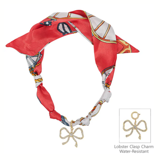 The What's Hot Red Scarf Necklace with Rhinestone Open Bow features a red and white patterned scarf, lobster clasp, and a water-resistant removable rhinestone bow charm for added style.