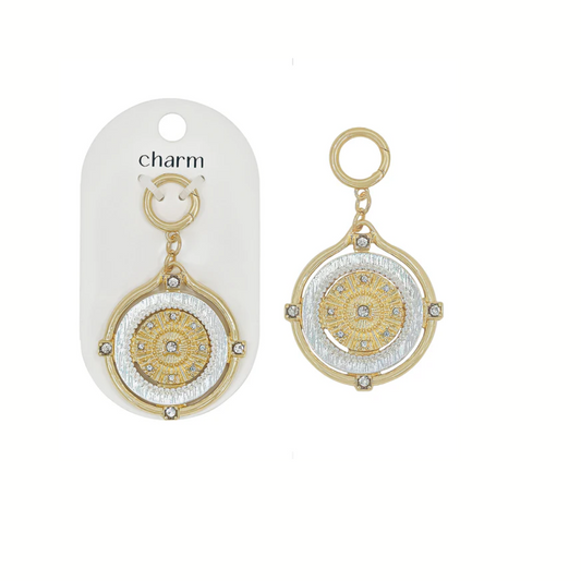 The What's Hot Gold and Silver Coin Charm for Scarf Necklace features a floral pattern and clear stones, shown on packaging and alone—perfect as statement jewelry.