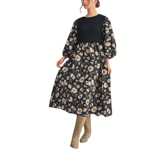 A woman models the Jodifl Solid Rib Knit Contrast Floral Midi Dress, featuring long sleeves and a beige floral print, paired with tan knee-high boots against a white background.