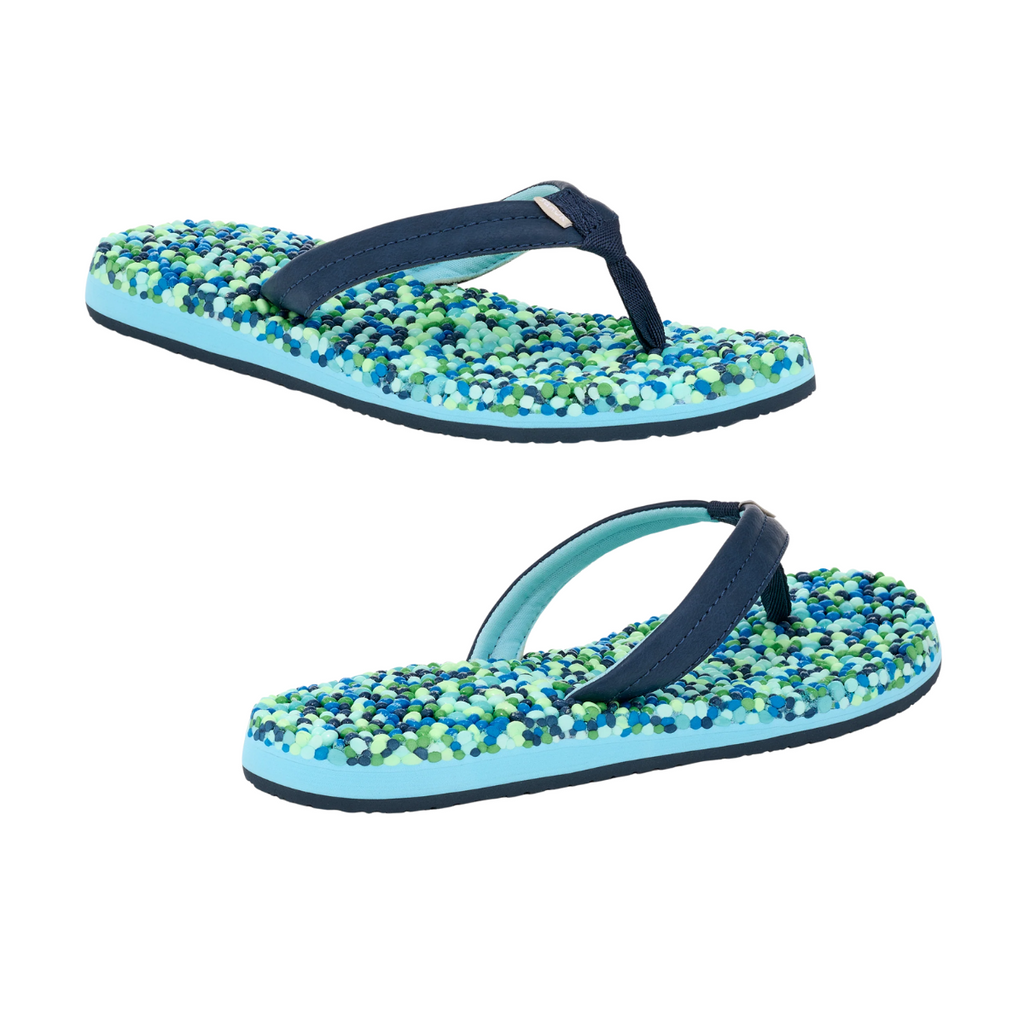 Sanuk's Bubblecush Flip Flops have blue straps and a vibrant sole adorned with green, blue, and white beads. They're water-friendly and quick-drying, ideal for sunny beach days.