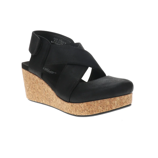The Case Closed in Black by CORKY'S FOOTWEAR INC is a black wedge sandal with wide crisscross faux leather straps, a cork platform sole, cushioned footbed, closed back, and open toe.