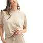 Woman wears the FASHION GO Brushed Hacci Dolman Top in Mocha with matching drawstring pants, styled in a relaxed fit and holding up the hem, set against a white background.