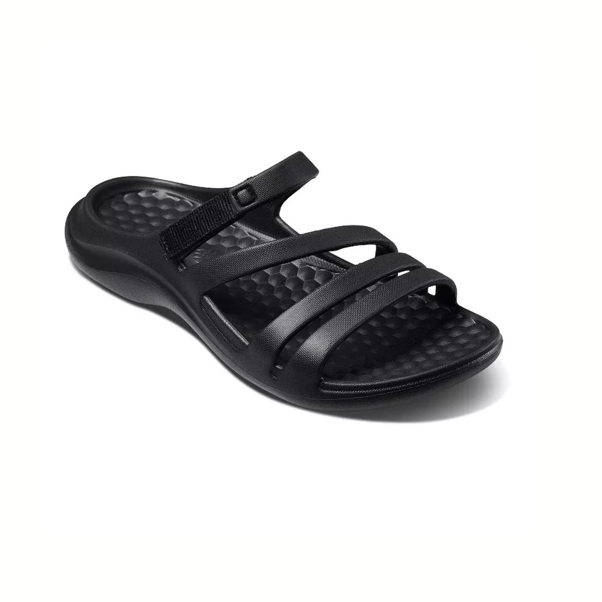 The Lakeshore Sandal in Black by JOYBEES features a textured footbed and multiple straps, including a small adjustable one. This lightweight sandal is perfect for seaside strolls. Shown from an angle. Main image
