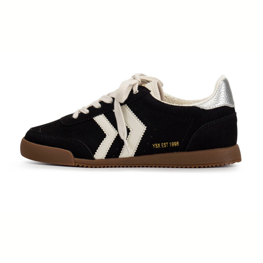 The Neevan Sneaker in Black Suede by Yellow Box features a gum sole, white laces, silver heel tab, cushioned insole, and "YBX EST 1998" text—making it the perfect go-to everyday sneaker.