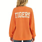 A football fan is seen from behind wearing the Tres Bien Paw Print TIGERS Cloudy Knit Top Orange, featuring a bold “TIGERS” graphic in large white letters across the back.