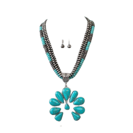 The Layered Squash Blossom Necklace by FASHION GO features turquoise and silver beads with a large flower-shaped pendant, inspired by classic designs, and comes with matching silver drop earrings.
