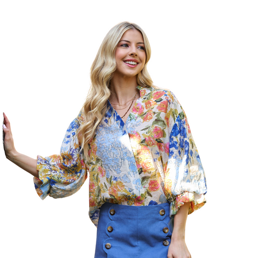 A woman smiles against a white background, wearing the FASHION GO Floral Printed Button Down Top with balloon sleeves and a blue buttoned skirt.