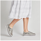 A person wearing a white plaid skirt and BERNIE MEV Jodie Rhinestone Embellished Python Print Sneakers stands against a plain background.