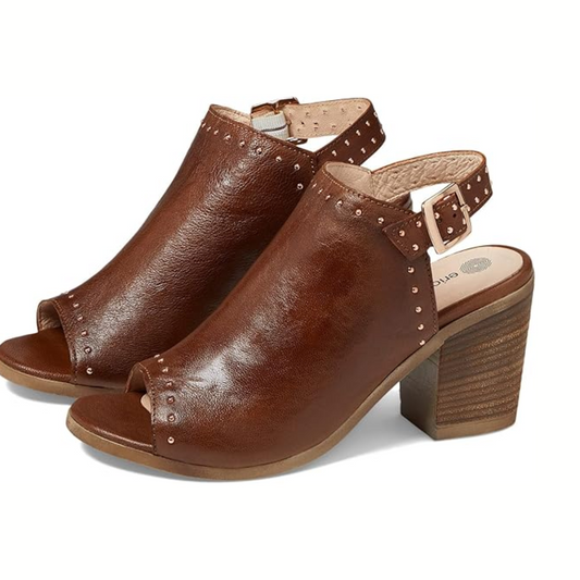The Eric Michael Tabitha Peep Toe Leather Bootie in brown features ankle straps, metal stud accents, and chunky stacked heels, all crafted from premium leather.