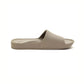 The Archies Slide Sandal in Taupe by ARCHIES FOOTWEAR LLC features a wide strap and contoured footbed. Displayed from the side on a white background, these beige slip-on slides offer excellent support.
