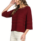 A woman poses with one hand in her hair, wearing the Vine & Love 3/4 Sleeve Sweater in maroon and white pants.