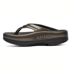 Side view of a single OOFOS LLC OOmega OOlala sandal in Titanium Mirror, showing its thick cushioned OOfoam™ sole for enhanced comfort and arch support, set against a white background.