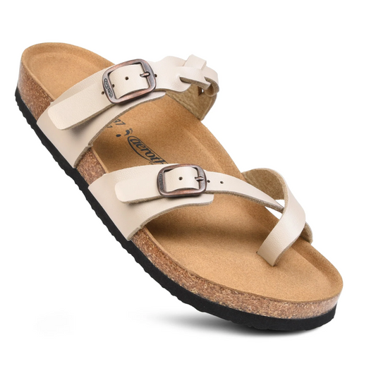 A single white strappy Irenic in Cream sandal by Aerothotic with buckle closures, arch support, and a cork footbed.