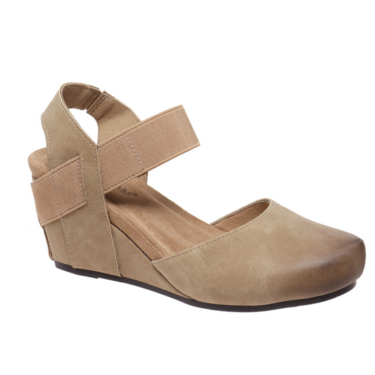 The Dash 1 Wedge by Pierre Dumas from OLEM SHOE CORP is a tan closed-toe women's faux leather wedge shoe featuring an adjustable elastic ankle strap and a thick, textured sole.