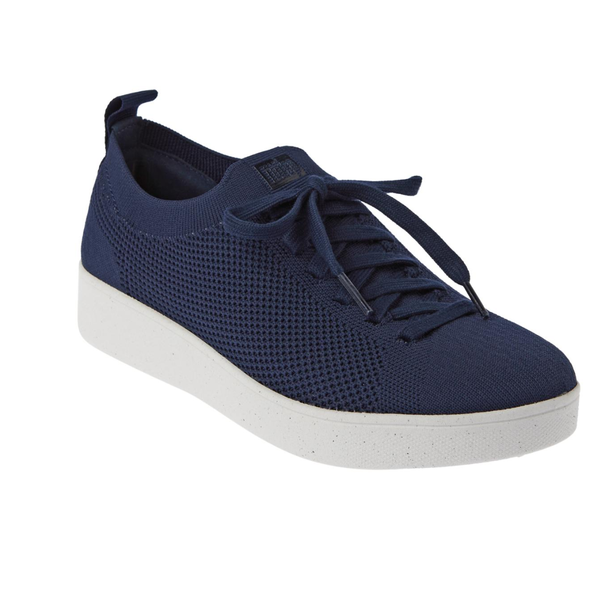 Introducing the Rally Knit Tennis Shoe in Navy by FIT FLOPS from FITFLOP USA LLC, a sleek dark blue sneaker with a white sole, navy laces, and a convenient pull tab at the back. Crafted from engineered knit for eco-friendly footwear.