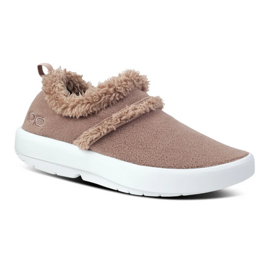 The Oocoozie in Chocolate by OOFOS LLC is a single slip-on shoe featuring a tan upper with vegan sherpa trim around the opening and across the top, a white sole, and OOfoam technology for exceptional comfort.