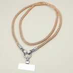 Sensibling Corp. Rhinestone Phone Lanyard Necklace in a gold-colored braided design with metallic connectors and a blank rectangular tag, displayed on a light beige background.