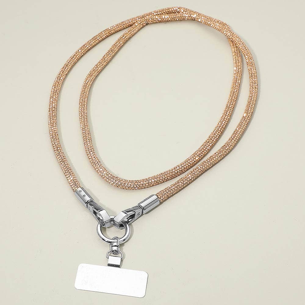 Sensibling Corp. Rhinestone Phone Lanyard Necklace in a gold-colored braided design with metallic connectors and a blank rectangular tag, displayed on a light beige background.