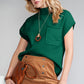 A woman wearing sunglasses, the green Patch Pocket Ribbed Knit Short Sleeve Sweater by Shewin, and a brown skirt holds a brown clutch.