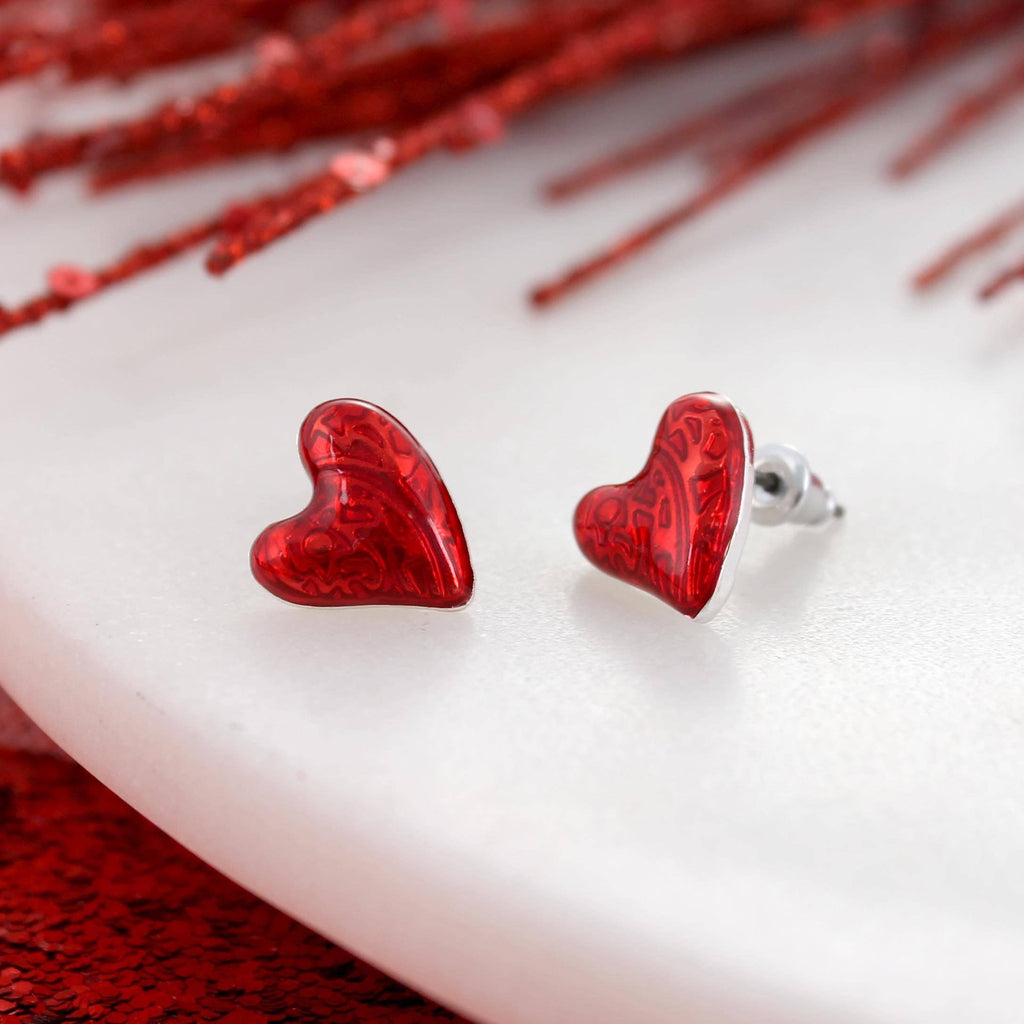 Add a touch of romance to your look with the Puffy Heart Valentine’s Day Stud Earrings by Seasons Jewelry—red puffy heart earrings featuring a subtle pattern, beautifully displayed on a white surface with red accents in the background, making them the ideal Valentine’s Day jewelry.