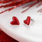 Add a touch of romance to your look with the Puffy Heart Valentine’s Day Stud Earrings by Seasons Jewelry—red puffy heart earrings featuring a subtle pattern, beautifully displayed on a white surface with red accents in the background, making them the ideal Valentine’s Day jewelry.