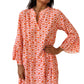 A woman smiles warmly, showcasing the Shewin Orange Floral Button V Neck Bell Sleeve Mini Dress against a plain background.