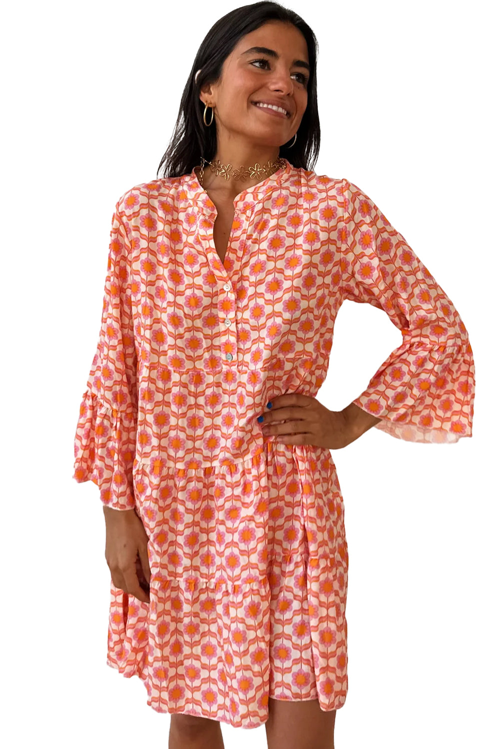 A woman smiles warmly, showcasing the Shewin Orange Floral Button V Neck Bell Sleeve Mini Dress against a plain background.