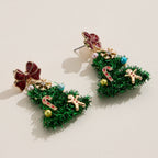 Bring festive flair to your style with the Tinsel Christmas Tree Drop Earrings by Lilla Haven—a delightful pair of holiday statement earrings adorned with colorful ornaments, finished with a red bow on top, and featuring playful candy cane and gingerbread man charms. These Holiday Ornament Charm earrings are perfect for spreading holiday cheer!.