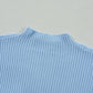 Close-up of Shewin's Patch Pocket Ribbed Knit Short Sleeve Sweater in light blue, featuring a high neckline, perfect for transitional weather, set against a beige background.