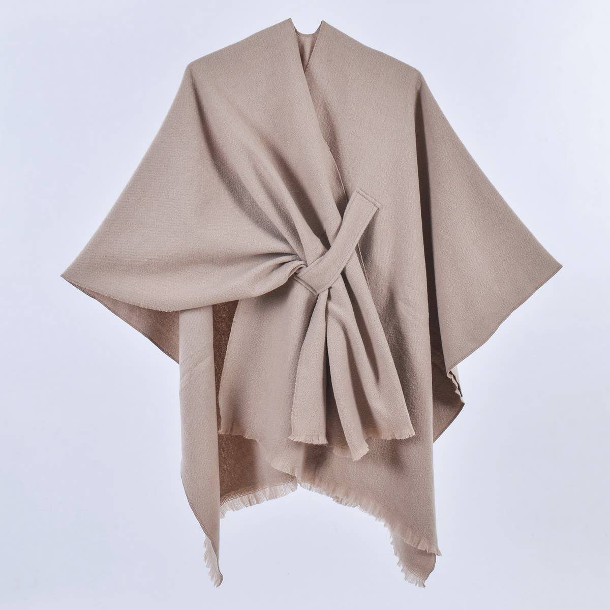 ACCITY’s SIMPLE SOLID COLOR OBLIQUE STRAP CAPE SHAWL in beige wool, draped and tied at the front, is showcased against a plain white background—a versatile layering piece for all seasons.