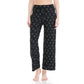 A person stands barefoot against a plain white background wearing Leggings Depot Buttery Soft Print Pajama Pants featuring a white bow pattern and an elastic waistband.