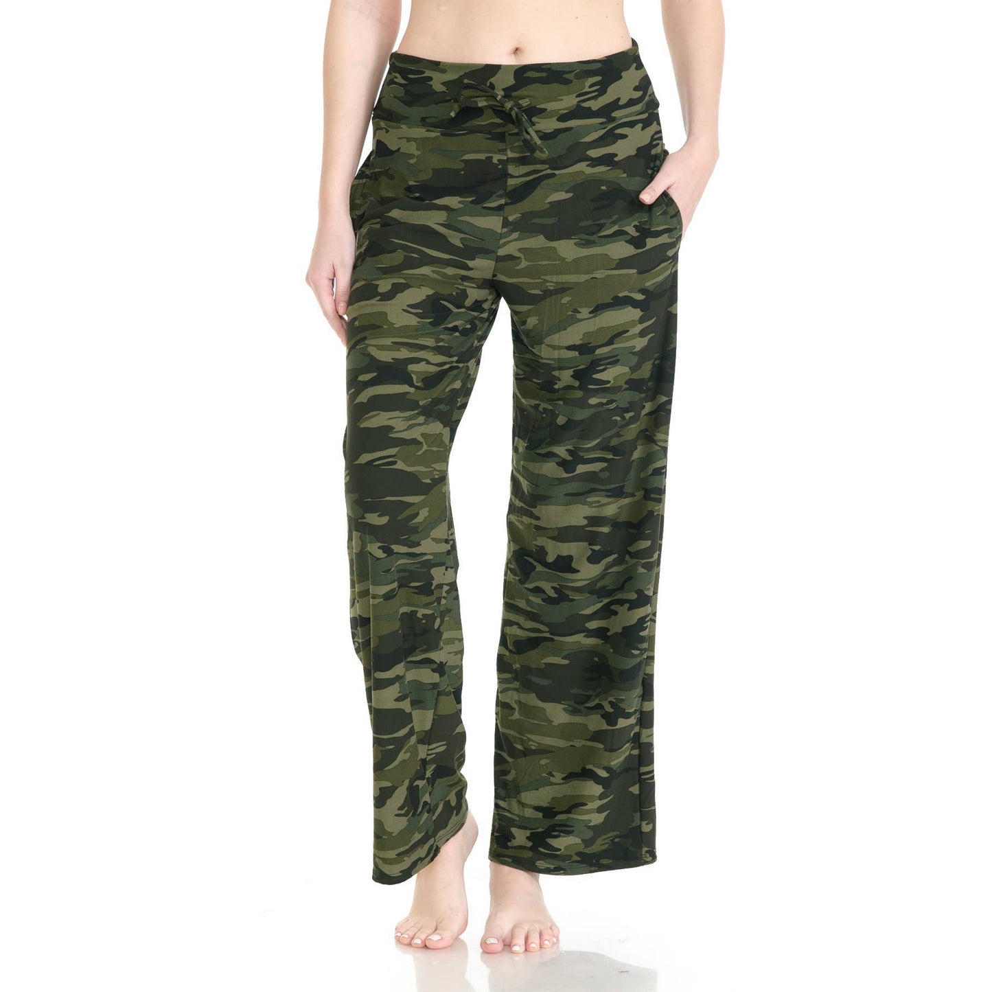 A person wears Leggings Depot Buttery Soft Print Pajama Pants in green camouflage with an elastic waistband, standing barefoot with hands in pockets against a white background.