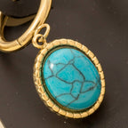 Gold keyring with an oval turquoise stone pendant in a textured gold frame—pairs perfectly with Anarchy Street's Oval Turquoise Stone Drop Earrings for a coordinated look.