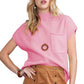 A person wearing a pink Shewin Patch Pocket Ribbed Knit Short Sleeve Sweater and a brown buttoned skirt poses confidently, showcasing a versatile style ideal for transitional weather.