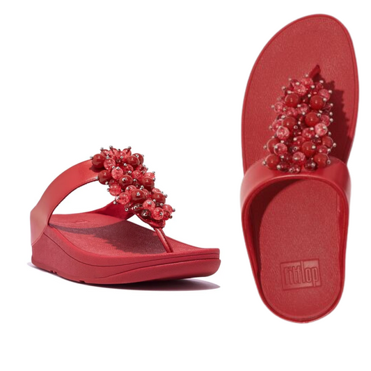 Fino Bauble Bead Flip Flop in Red by FIT FLOPS with elevated faux-leather sole and decorative bauble beads on the strap. Left sandal shown from a front-side angle, right sandal displayed from a top view, both featuring Microwobbleboard midsoles for added comfort by FITFLOP USA LLC.