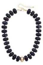 Add bold elegance to any outfit with the San Sebastián Beaded Resin Necklace by Canvas Style, featuring large round black resin beads, a single central gold bead, small gold spacers, and a gold adjustable clasp.