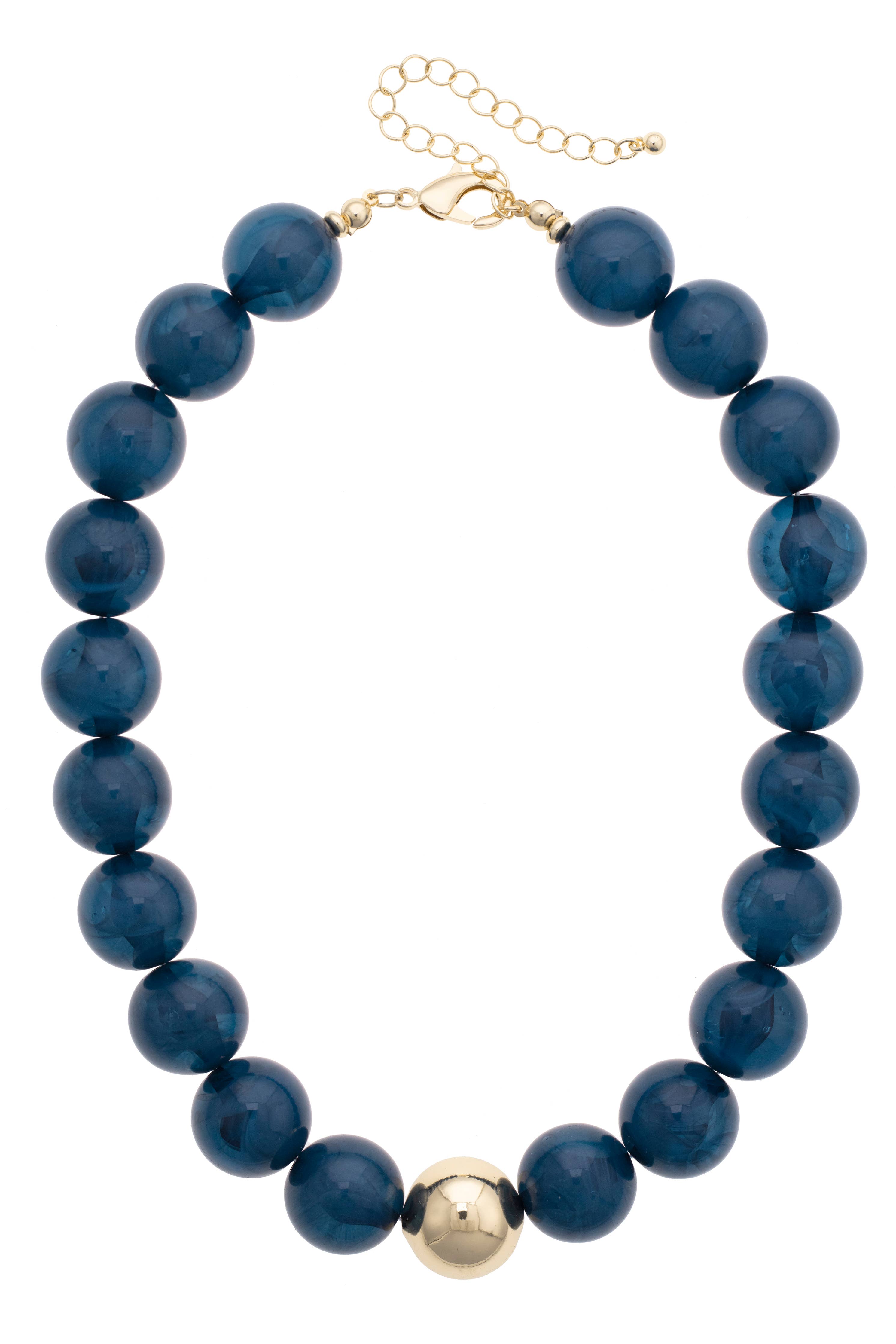 The Marjorie Fall Beaded Necklace by Canvas Style features oversized dark blue resin beads, a single central gold bead, and a gold clasp with adjustable chain.