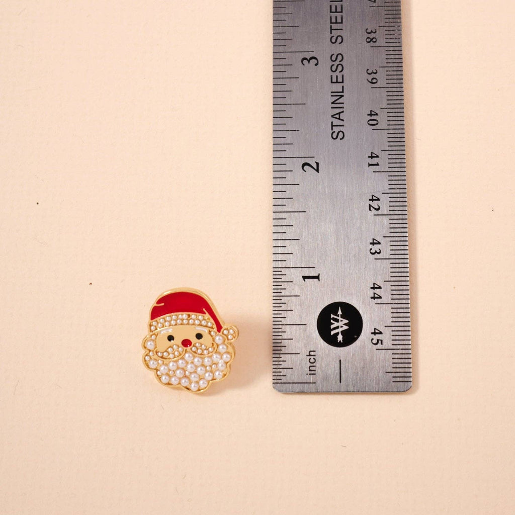 The Pearl Santa Claus Stud Earrings by Lilla Haven, featuring rhinestone detailing and measuring approximately 1 inch tall next to a stainless steel ruler, make a charming Christmas accessory perfect for the holiday season.