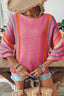 A woman in a wide-brim hat wears the 1 the Woman Spring Striped Detail Wide Sleeve Lightweight Knit Sweater with denim shorts, bracelets, and holds a woven tote bag by a wooden table and chairs.