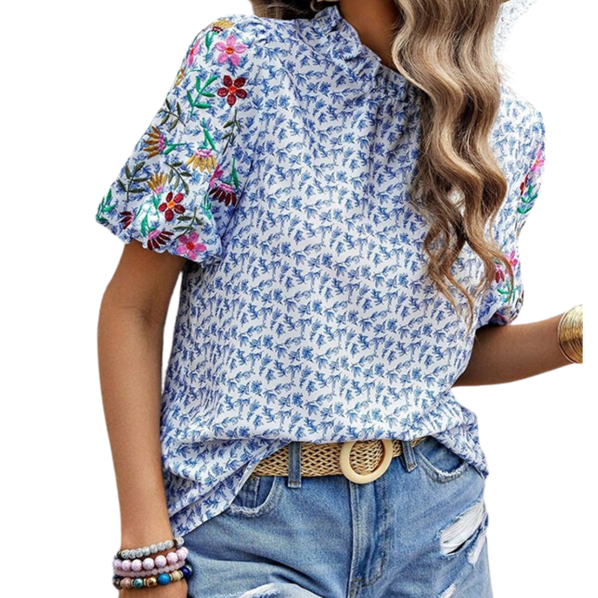 A person wearing a short-sleeved, blue patterned blouse with colorful floral embroidery on the sleeves, paired with distressed denim shorts and accessorized with a belt and bracelets. The look is completed with an elegant, FASHION GO Printed Wavy High Neck Color Top in Blue that ties everything together seamlessly.