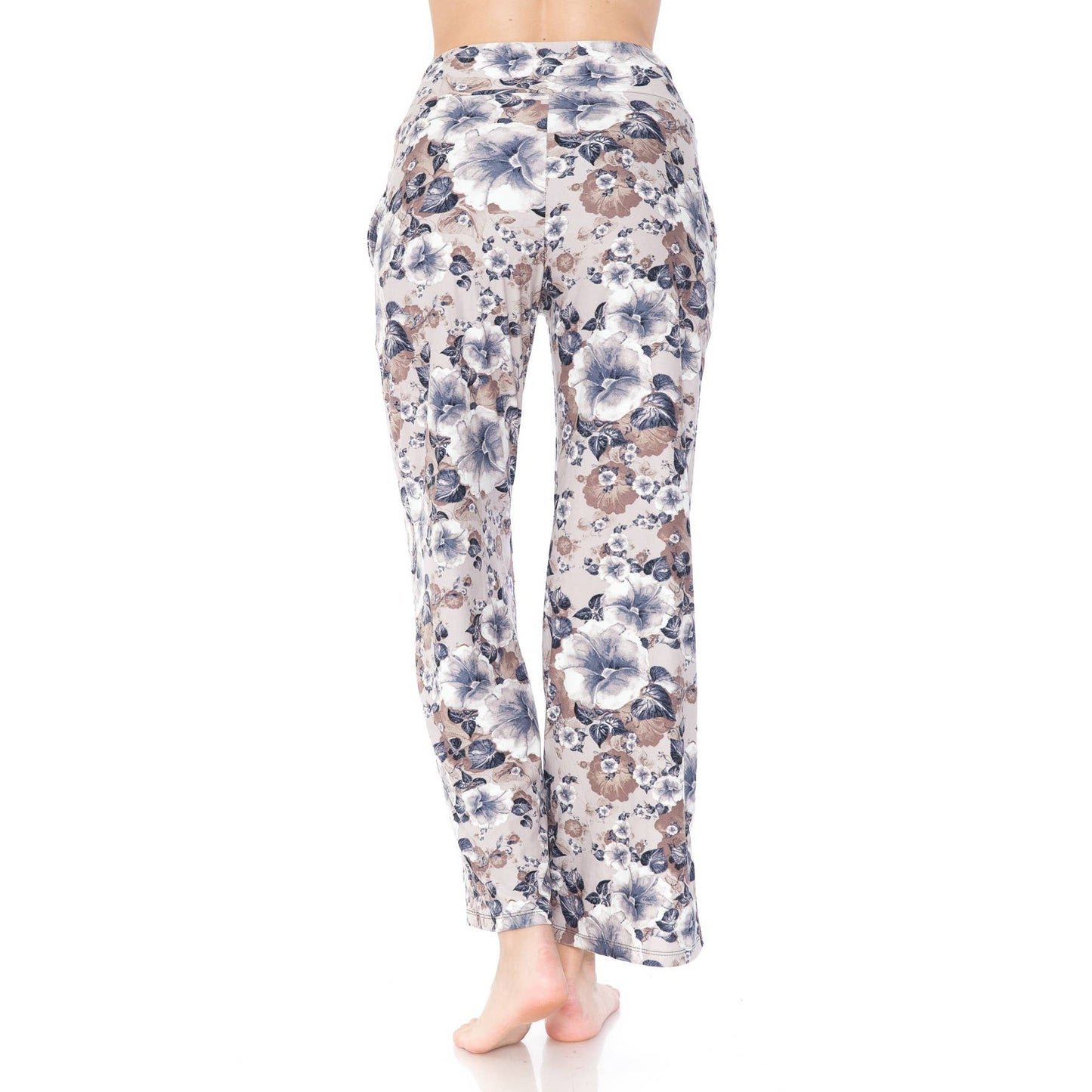 A person stands barefoot, facing away, wearing Leggings Depot Buttery Soft Print Pajama Pants with a relaxed fit, elastic waistband, and functional pockets in a light-colored floral print against a white background.