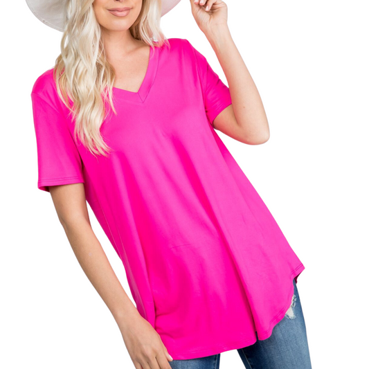 Person wearing a bright pink, FASHION GO Butter Soft Solid Basic T, blue jeans, and a white hat against a white background.