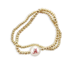 Seasons Jewelry’s Alabama Gold & Pearl Logo Stretch Bracelet Set is displayed on a white background—a subtle yet stylish accessory featuring gold beading and a single white bead with a red “A,” perfect for any University of Alabama fan.
