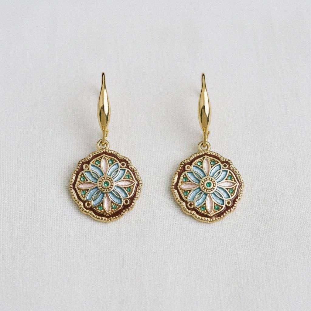 The Enamel Drip Art Dangle Earrings by Ellemadera feature round, floral-patterned enamel pendants in teal, pink, and white on gold dangle settings. Displayed on a white background, these palace style earrings evoke vintage-inspired charm and bring elegant flair to any outfit.