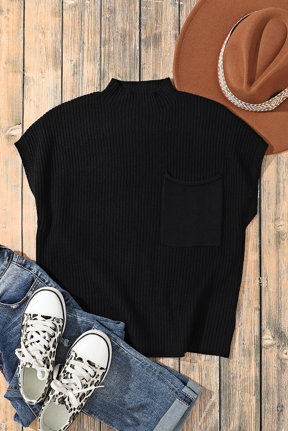 The Shewin Patch Pocket Ribbed Knit Short Sleeve Sweater, ideal for transitional weather, is styled with blue jeans, a brown hat, and leopard print sneakers on a wooden surface.