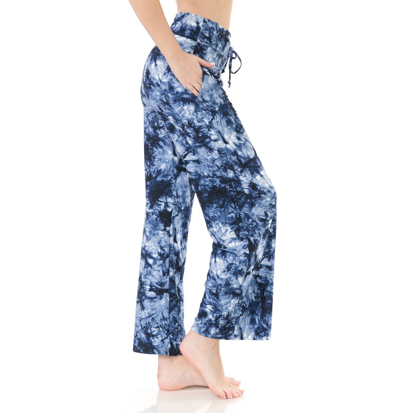 A person stands barefoot with hands in pockets, wearing Leggings Depot Buttery Soft Print Pajama Pants in blue and white tie dye, featuring an elastic waistband, photographed against a white background.