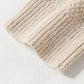 Close-up of Shewin's Khaki Cable Knit Colorblock Crew Neck Drop Shoulder Sweater featuring textured beige knit fabric with rib-knit and diamond patterns on a light surface.