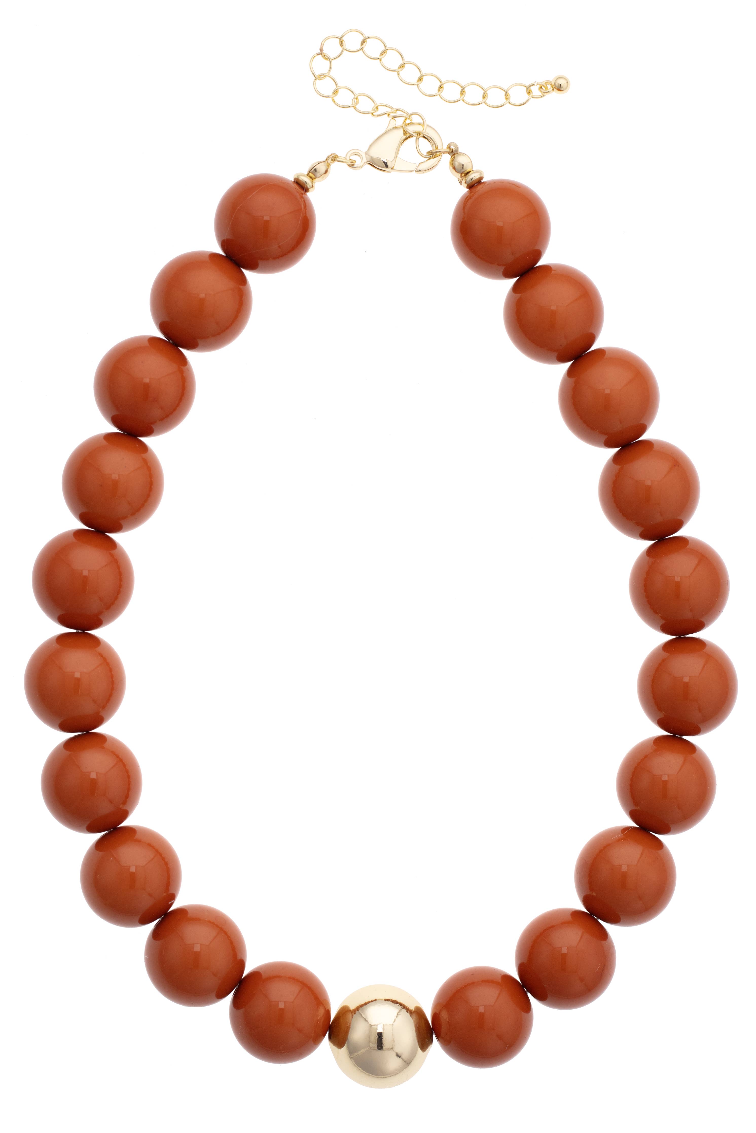 The Marjorie Game Day Beaded Necklace by Canvas Style features chunky, oversized round brown beads accented with a single central gold bead and is finished with a gold chain extender and clasp—an unforgettable statement necklace perfect for elevating any look.