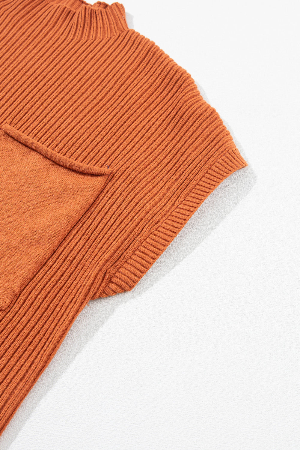 A close-up of Shewin's Patch Pocket Ribbed Knit Short Sleeve Sweater in rust, ideal for transitional weather, displayed on a light background.